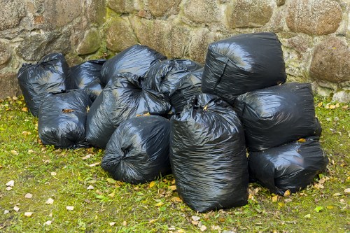 Workers managing waste containers with protective equipment